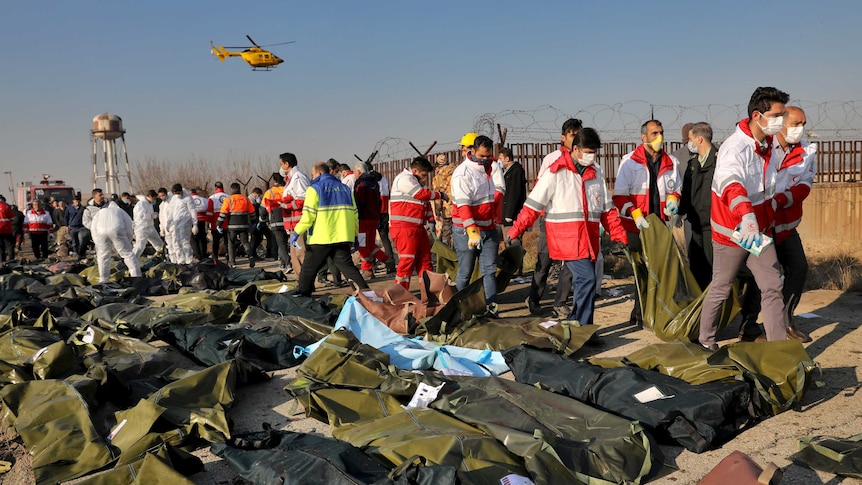 Rescue workers recover bodies of plane crash victims.