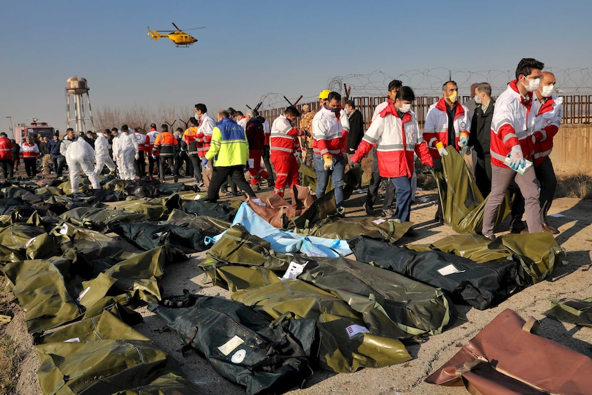 Rescue workers recover bodies of plane crash victims.