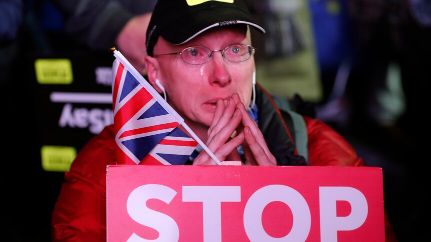 An anti-Brexit protester cries as he waits in Parliament square for the outcome of the vote.