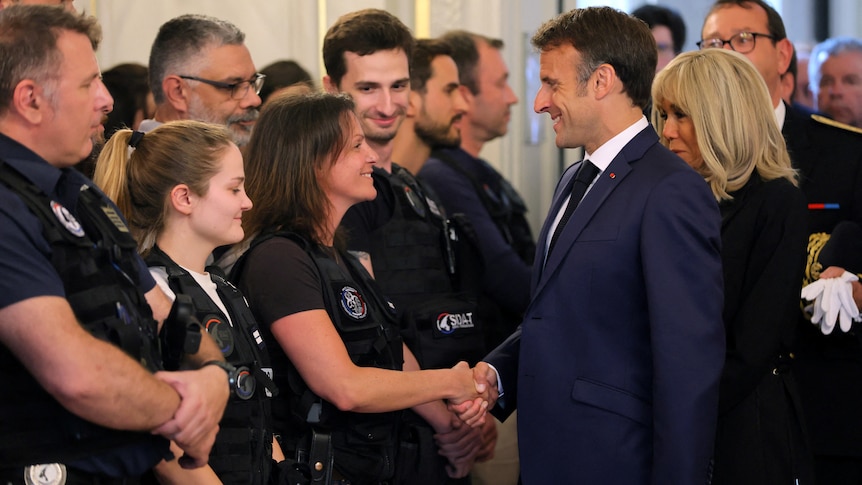 the president shakes hands with a female police officer 