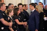 the president shakes hands with a female police officer 