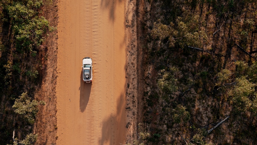 An aerial view of a 4WD on a dirt road in remote Arnhem Land.