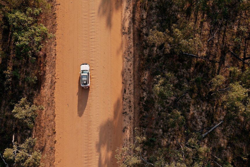 An aerial view of a 4WD on a dirt road in remote Arnhem Land.