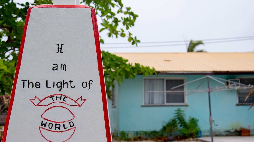 A house with a sign out the front that reads, 'I am the light of the world'.