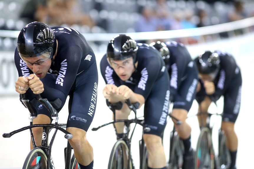 Four men wearing black lycra riding bikes