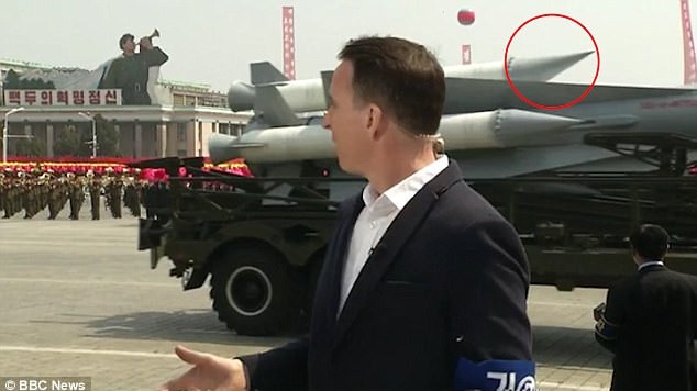 A BBC reporter stands in front of a North Korean missile on a vehicle.