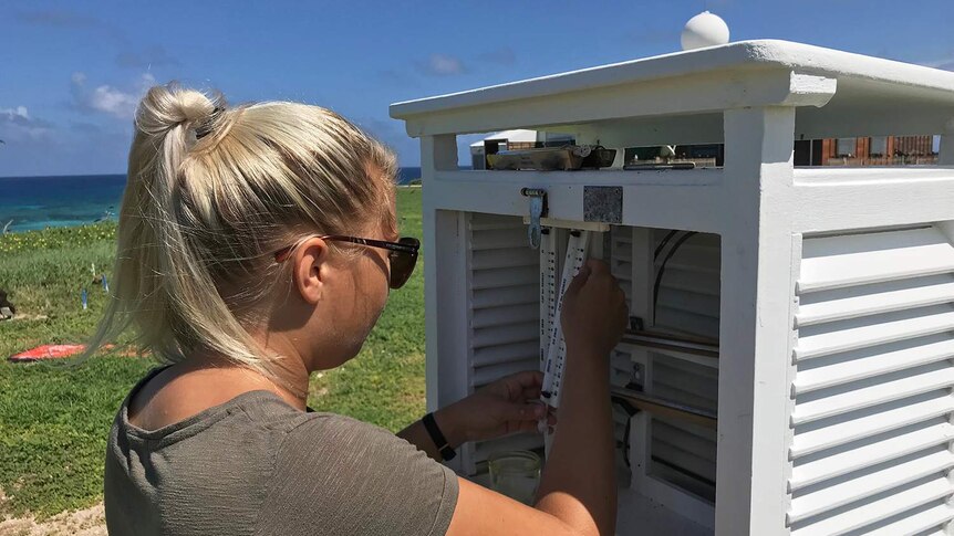 Amy Carroll performing routine maintenance on instruments at the Bureau of Meteorology Station on Willis Island.