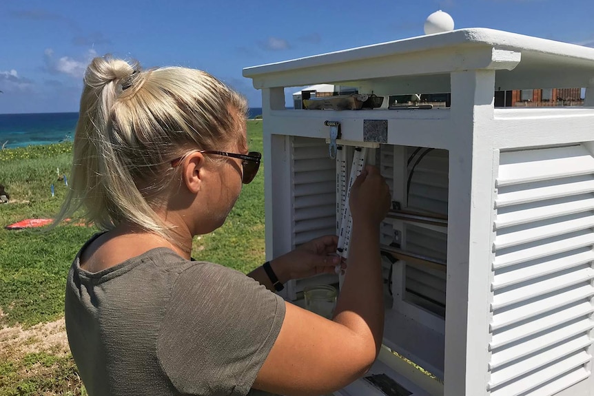 Amy Carroll performing routine maintenance on instruments at the Bureau of Meteorology Station on Willis Island.