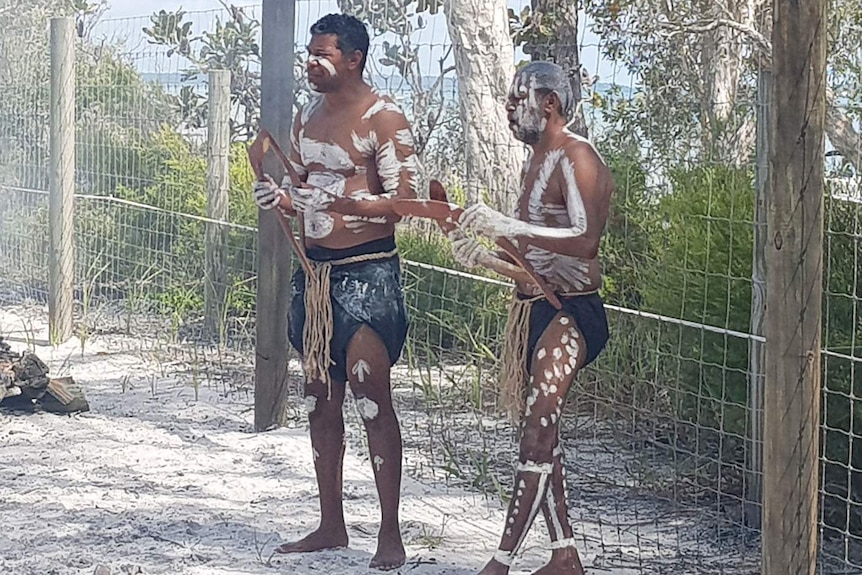 Two men in traditional costume with instruments on Fraser Island