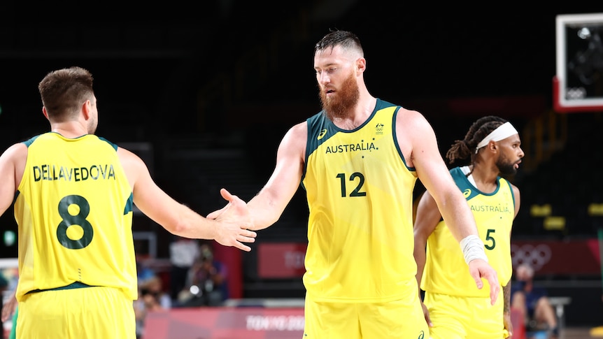 A man wearing a yellow jersey slaps hands with another man wearing a yellow jerset