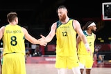 A man wearing a yellow jersey slaps hands with another man wearing a yellow jerset