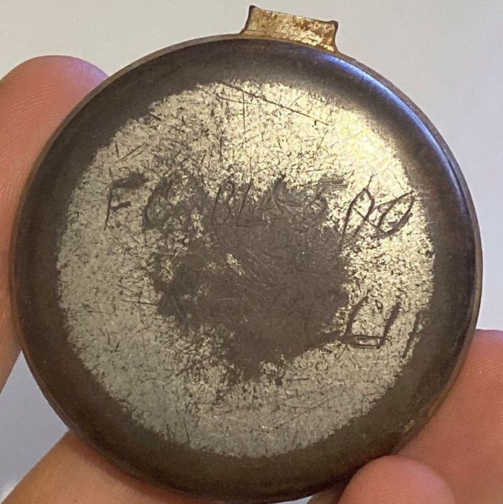 The back of a 100 year old pocket watch with " F.C. BLK 500" engraved on it