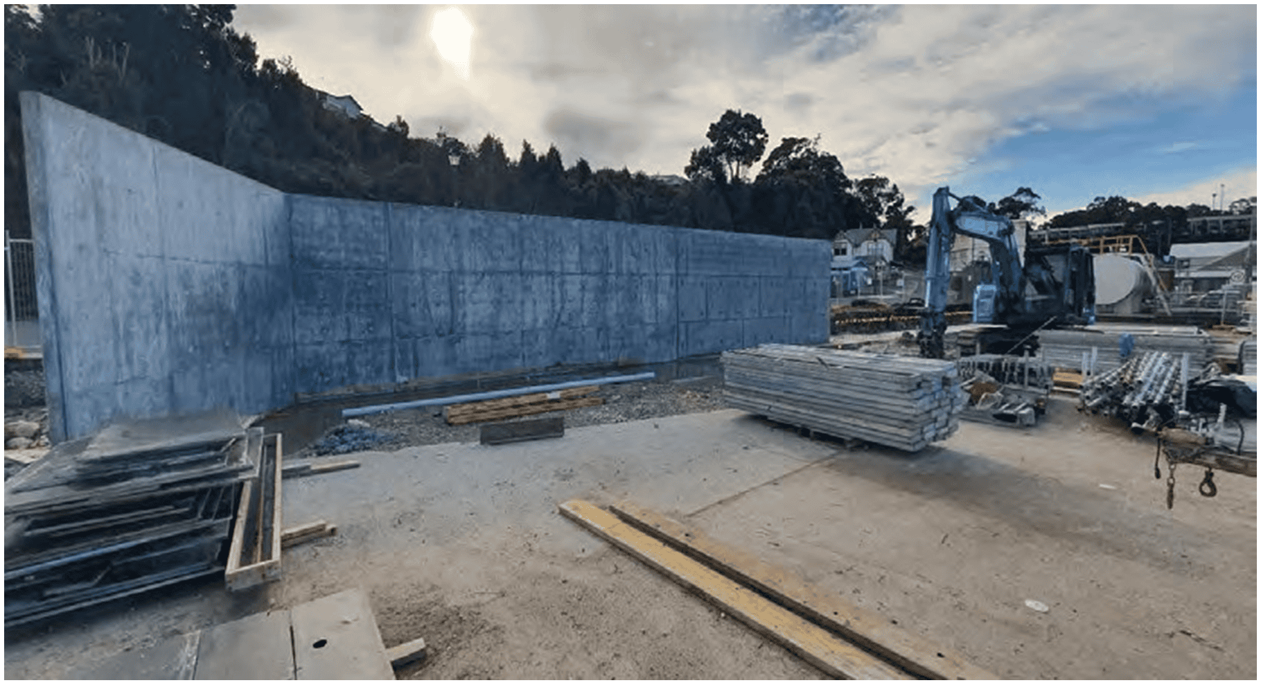 Um grande muro de concreto cercado por equipamentos de construção.