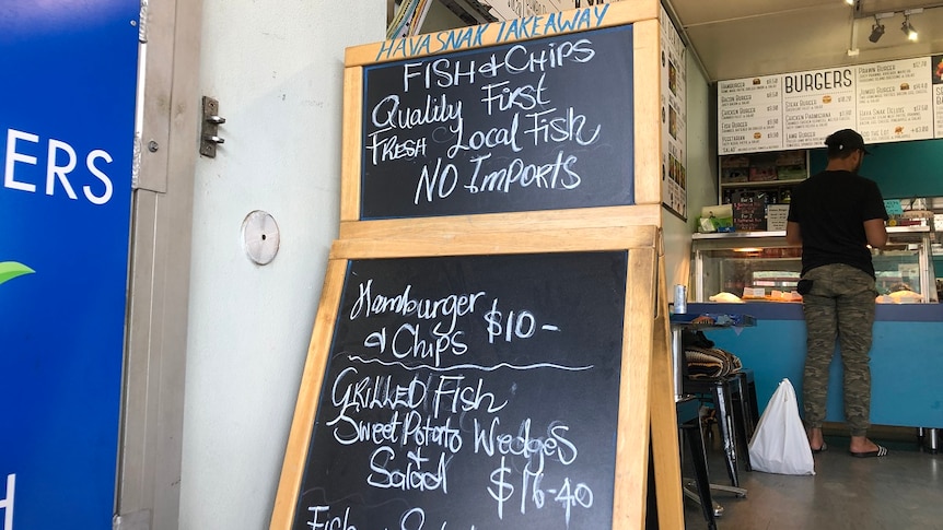 A blackboard in front of a takeaway shop announces 'no imports', only 'fresh local fish' on menu