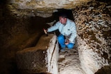 Excavation worker cleaning coffin