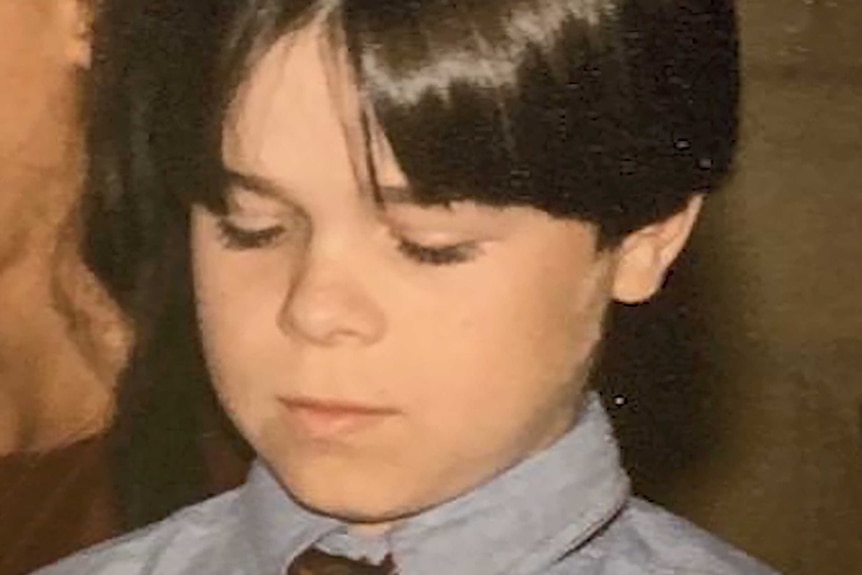 A head and shoulders picture of a young Gerard Ross looking downwards.