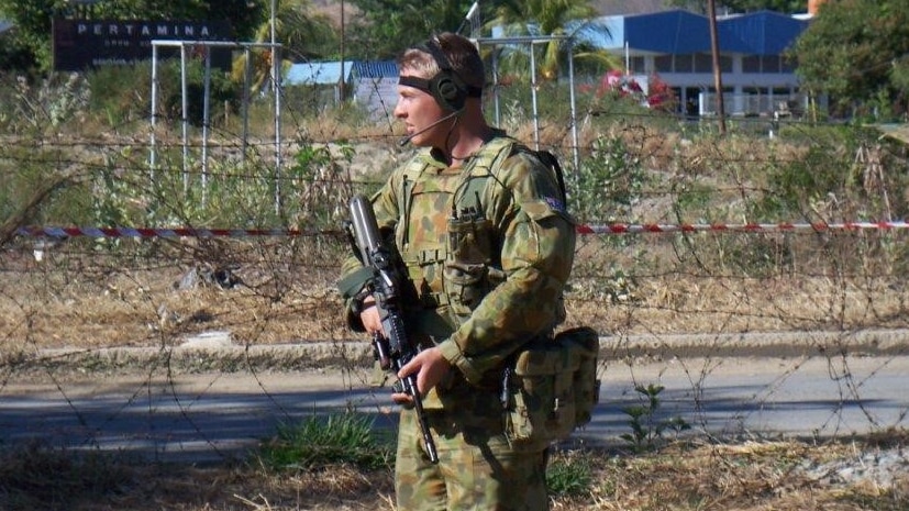 Australian soldier Matthew Model stands with his weapon in East Timor where he served with the Army.