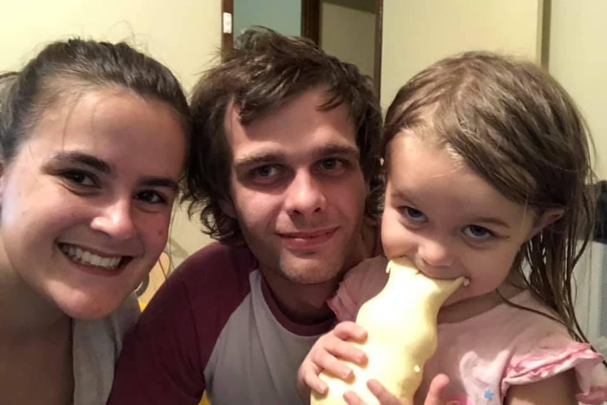 Young couple with daughter, 4, who is eating a white chocolate bunny