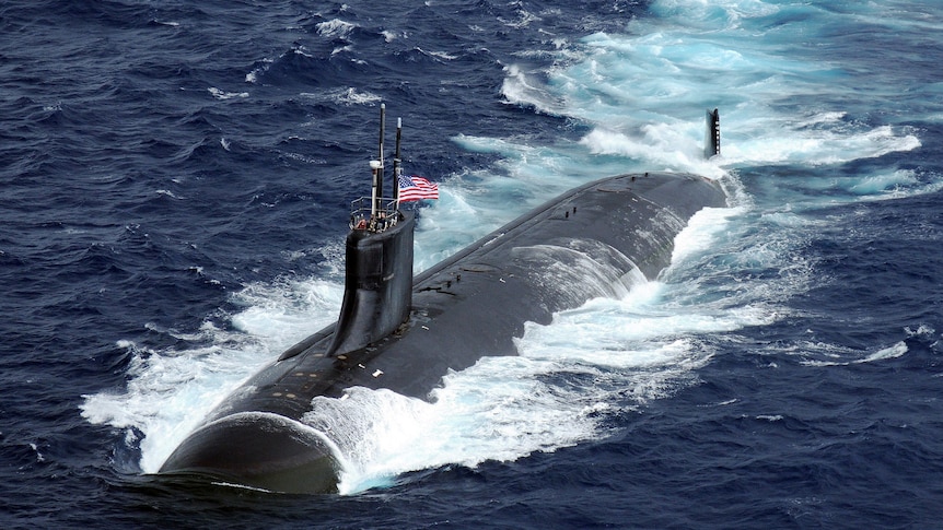 Submarine with Unites States flag is semi submerged in water