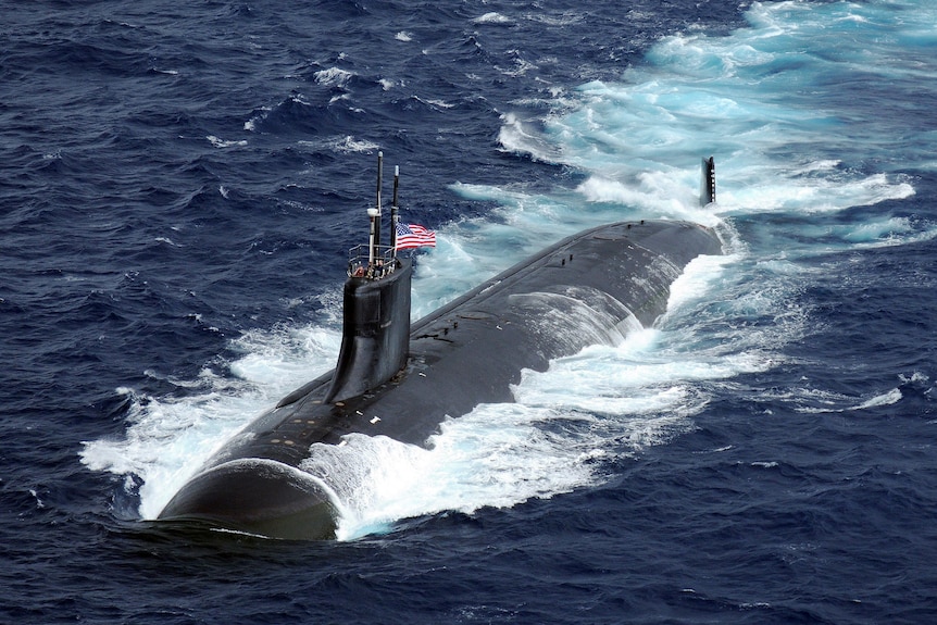 Submarine with Unites States flag is semi submerged in water