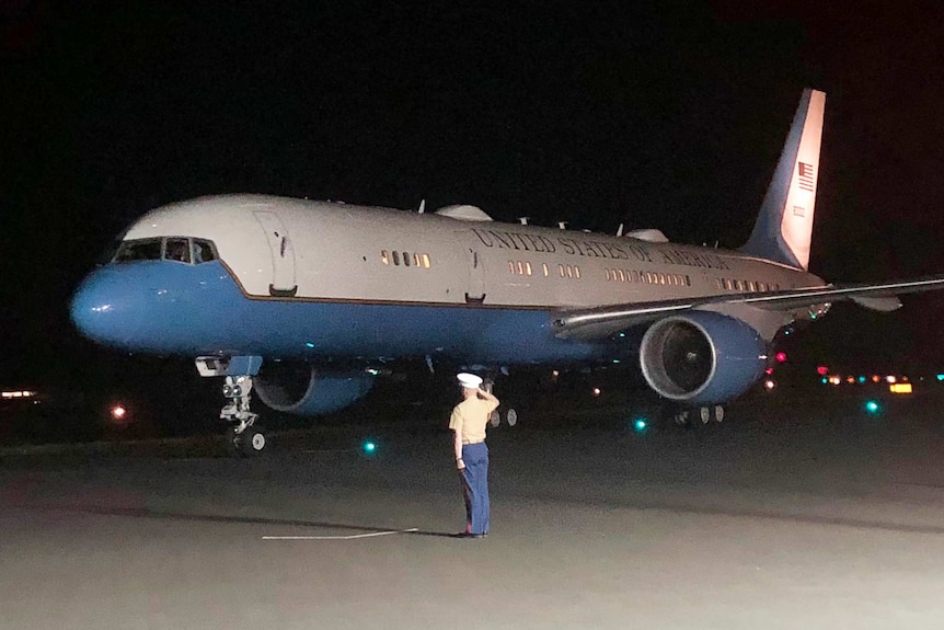 Air Force II aircraft on the tarmac at Cairns Airport with soldier saluting.