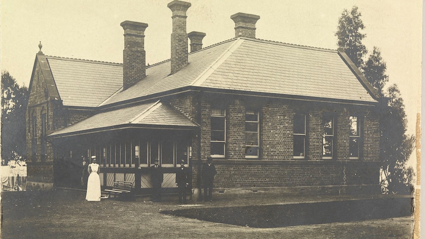 Sepia toned historic photo of exterior of an infectious diseases hospital in Launceston with staff.