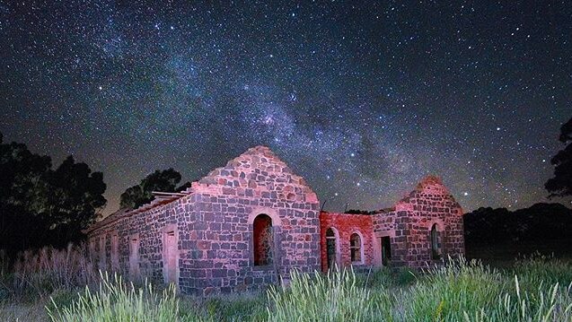 Ruins of stone building under a night sky