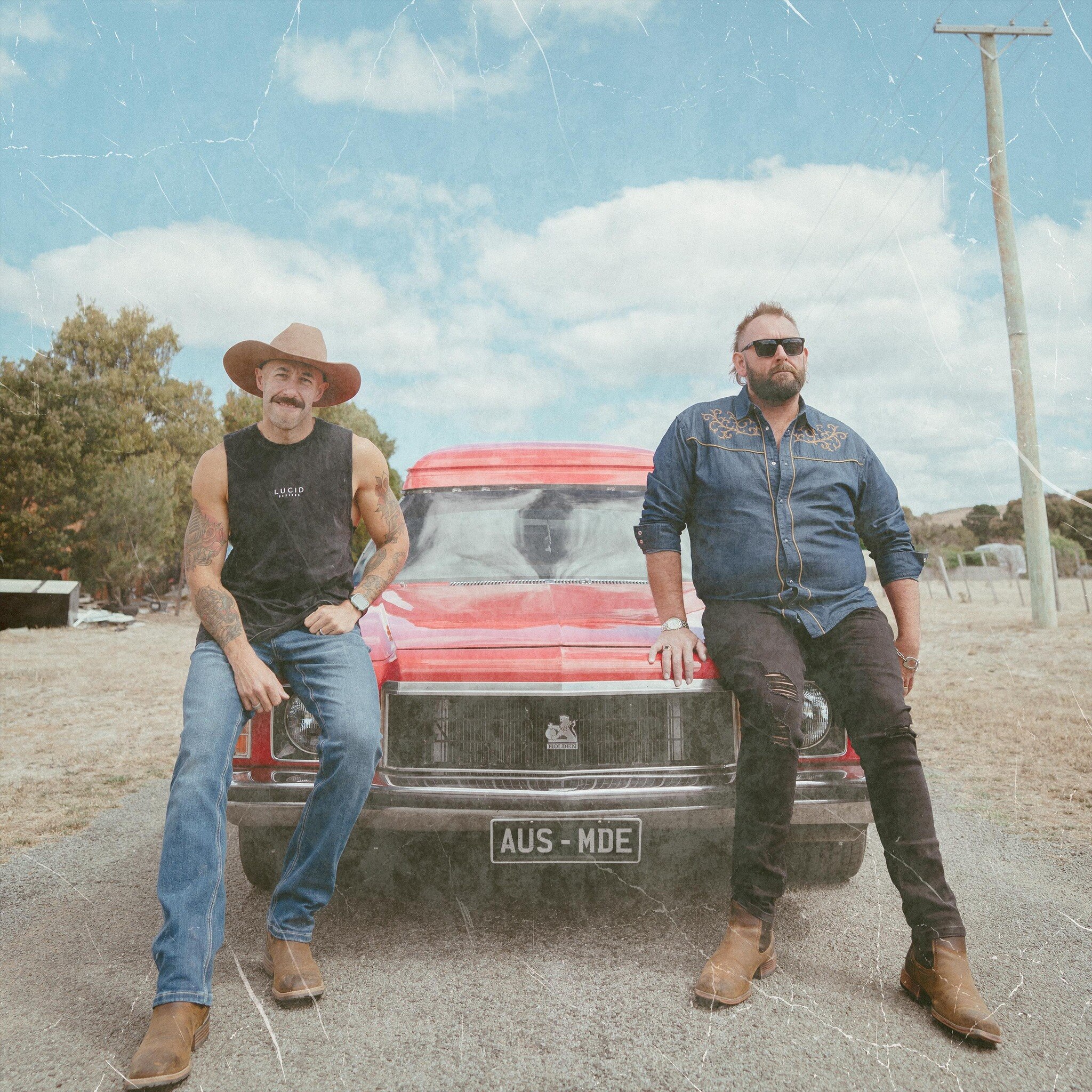 The Wolfe Brothers sit on the bonnet of a red panel van