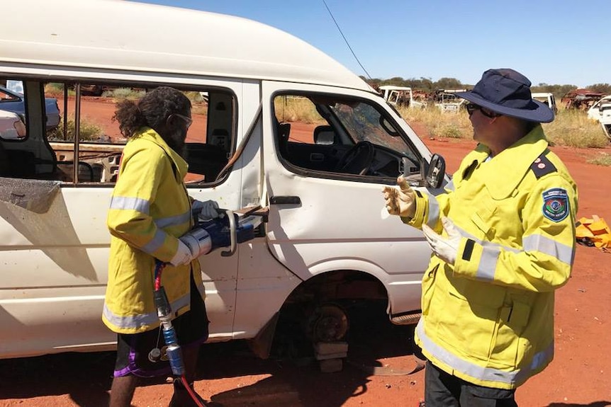 Ngaanyatjarra emergency response volunteer practices using the jaws of life on a broken down vehicle.