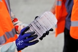 Close up of hands holding a cylinder-shaped piece of ice