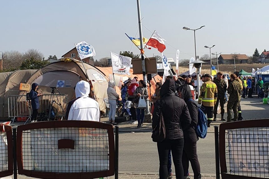 People at the Ukraine-Poland border with tents and barricades