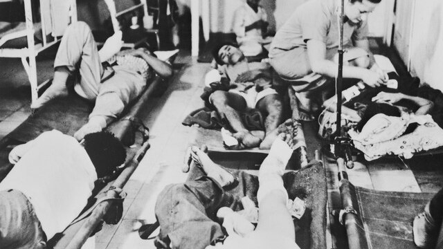Six people lying on stretchers after surgery.