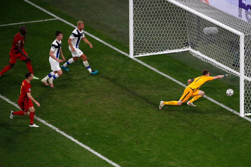 A goalkeeper dives frantically but fails to stop the ball crossing the line for an own goal at Euro 2020. 