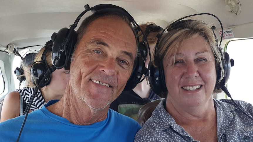 Brian Hocker, wearing a blue shirt on the left, with Merinda Kyle, in a patterned blouse on the right in a helicopter.