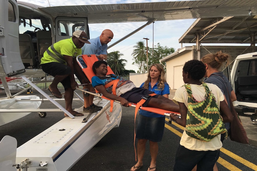 A patient on is unloaded on a stretcher from a float plane.