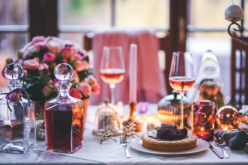 A table set for a dinner party with flowers, candles and wine.