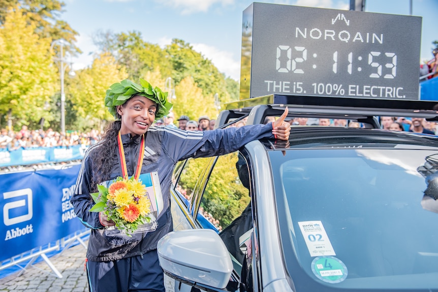 Tigist Assefa points to her world record time