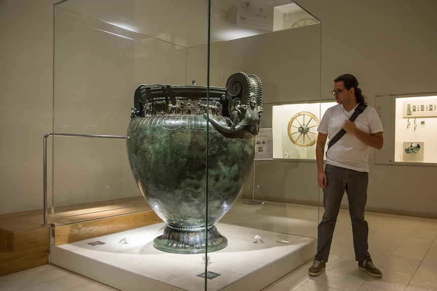 Giant bronze vessel with man standing next to it