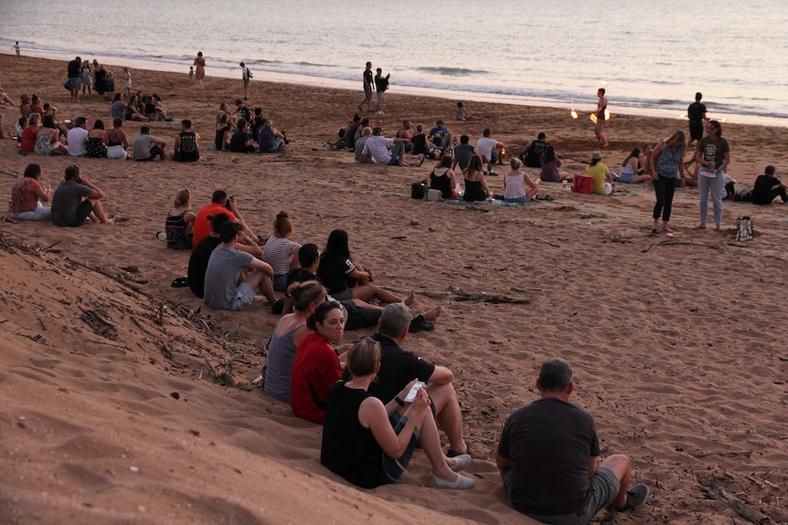 A photo of crowds sitting on Darwin's Mindil beach at sunset.