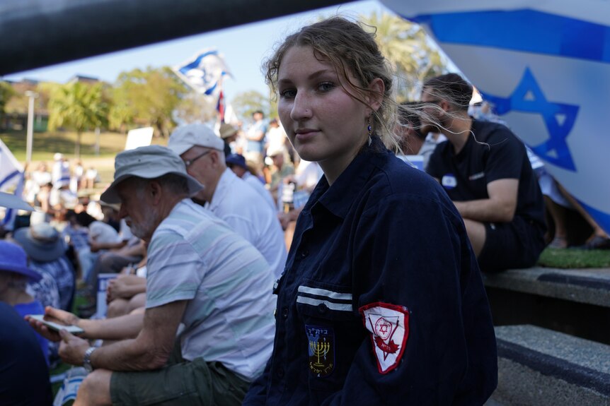 a young woman at a pro-israel rally in brisbane looks at the camera