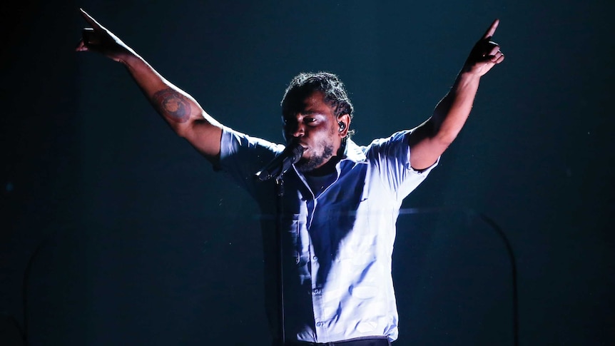 Kendrick Lamar points to the sky at the Grammys.