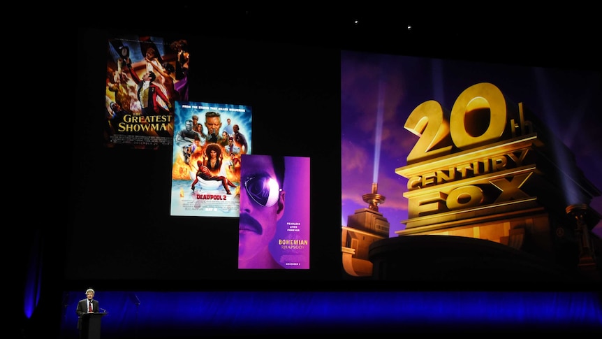 Alan Horn, chairman of The Walt Disney Studios, speaks underneath poster images for 20th Century Fox films.