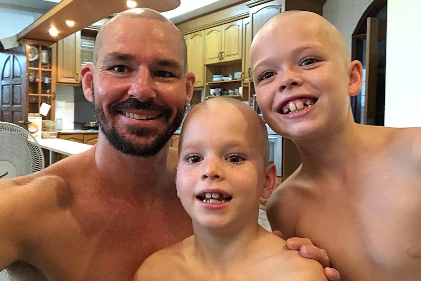 A dad with two young boys all with shaved heads