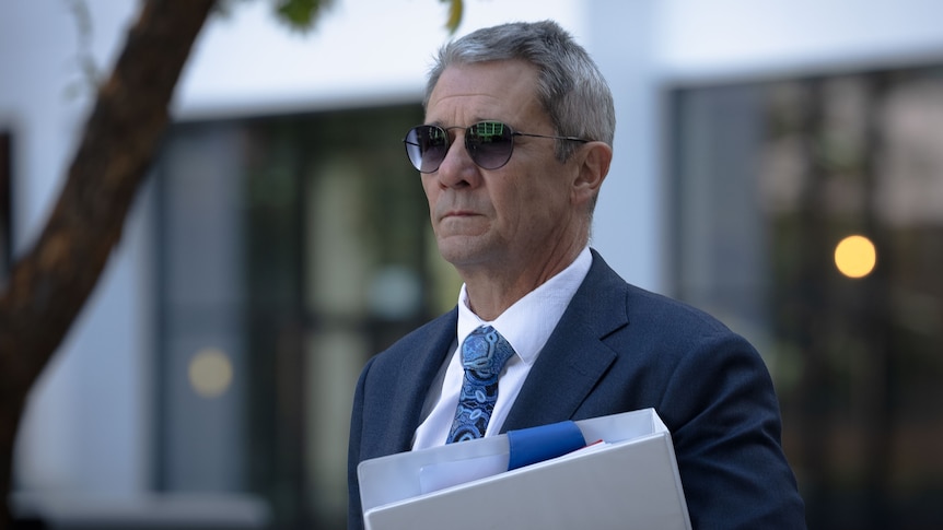 Shane Drumgold holding a folder walking into ACAT. 