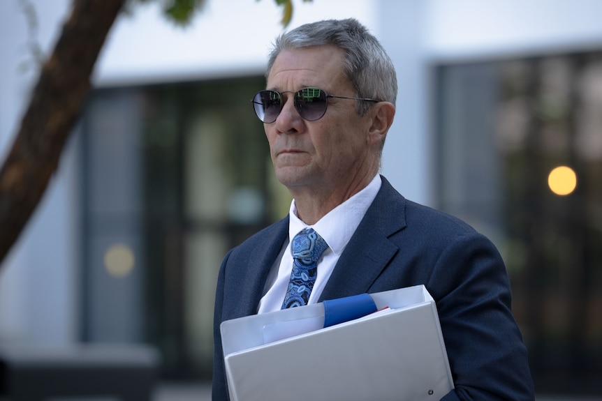 Shane Drumgold holding a folder walking into ACAT. 