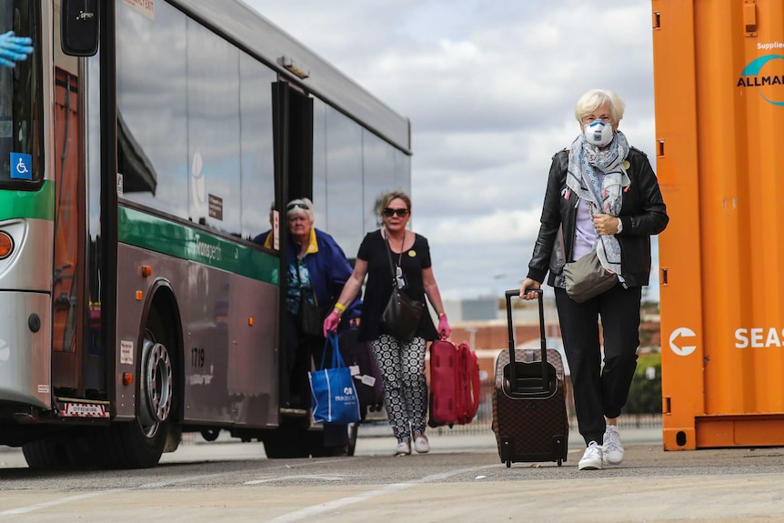 Three women, one with a mask, get off a transperth bus