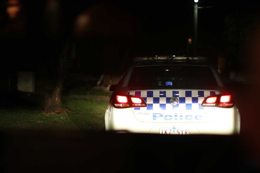 The rear of a police vehicle at night.