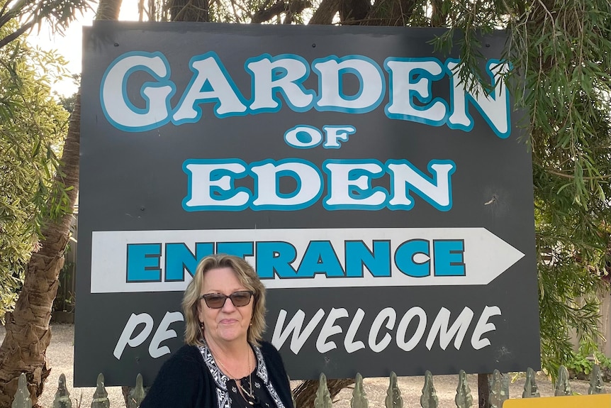A woman standing in front of a "Garden of Eden" sign