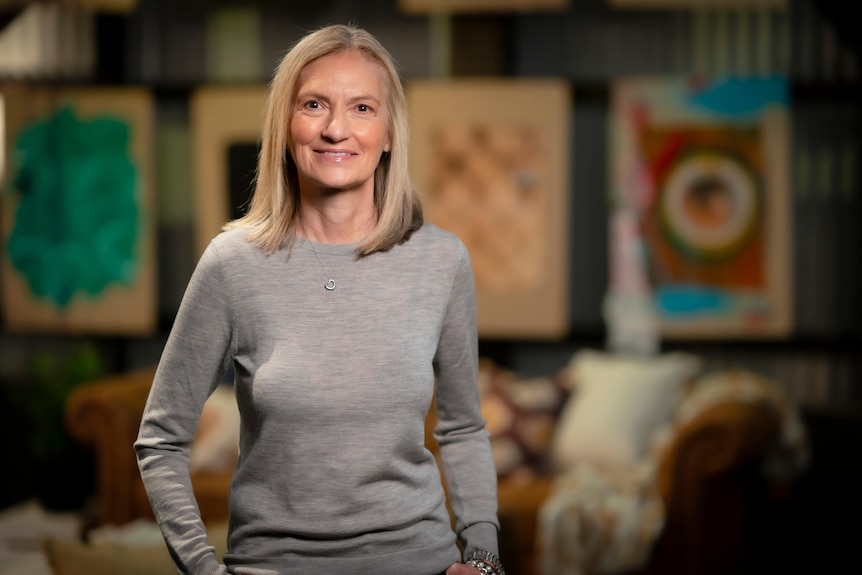 A blonde woman smiles at the camera