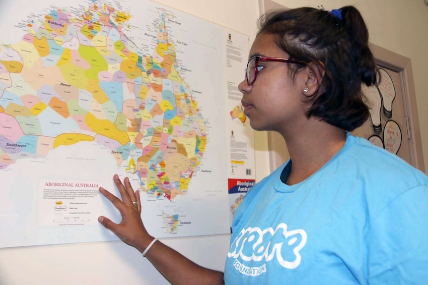 Shannieka Martino examines a map on Australia on a wall.